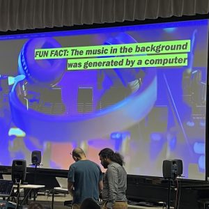 Image of a presentation screen with colorful graphics and text stating a fun fact about computer-generated music.